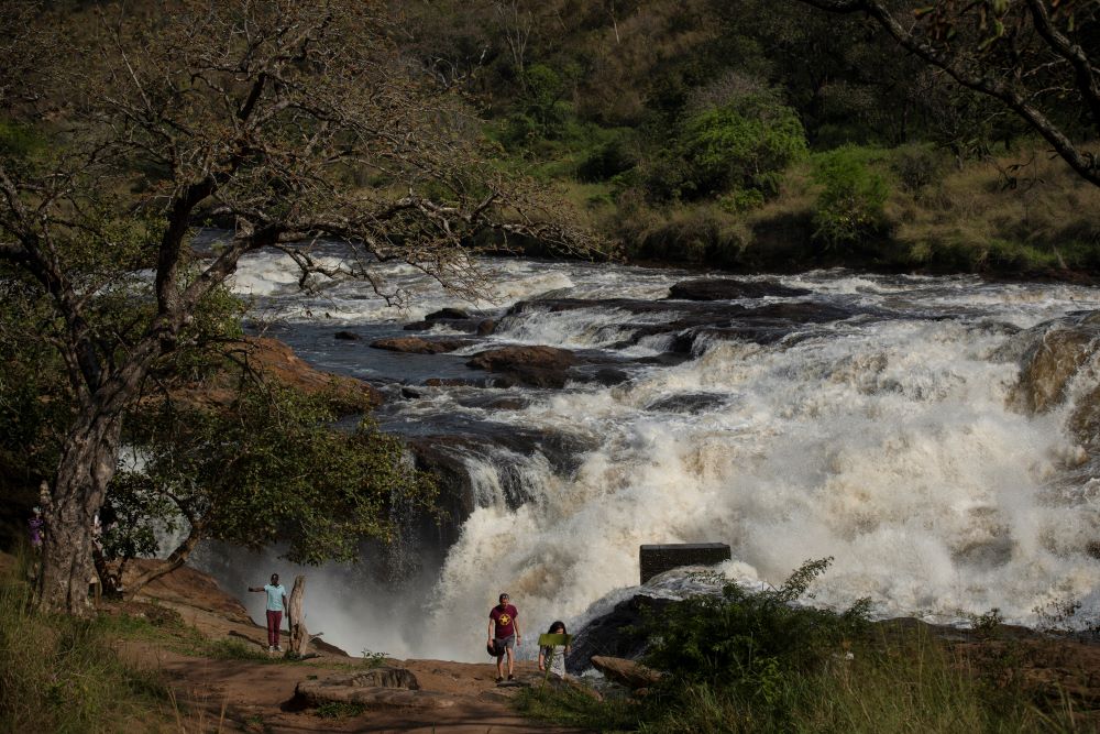 Tourists walk at the top of the waterfalls in Murchison Falls National Park, northwest Uganda, on Feb. 22, 2020. The East African Crude Oil Pipeline goes through part of the park. (AP)