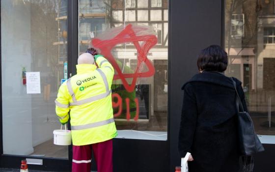 A worker removes antisemitic graffiti on a shop window in the Belsize Park neighborhood of London Dec. 29, 2019. (CNS/Reuters/Aaron Chown)