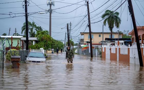 A member of the Puerto Rico National Guard wades through water Sept. 19, 2022, in search for people to be rescued from flooded streets in the aftermath of Hurricane Fiona in Salinas, Puerto Rico. (CNS/Ricardo Arduengo)