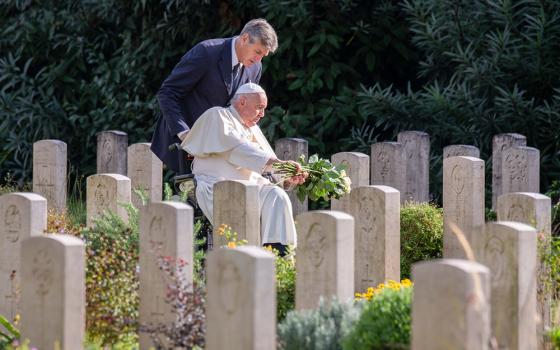 Pope Francis leaves a bouquet of white roses at a grave before celebrating Mass at the Rome War Cemetery, the burial place of members of the military forces of the Commonwealth in Rome Nov. 2 for All Souls' Day. (CNS/Paolo Galosi, pool)