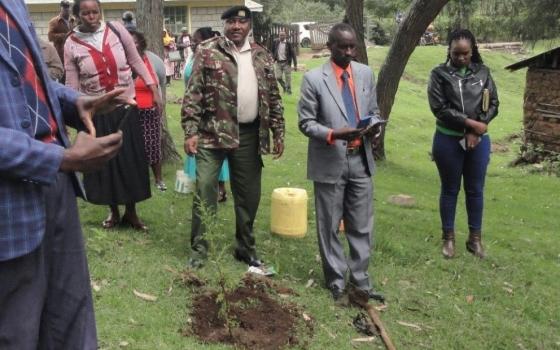 Officials with shovel prepare to plant trees