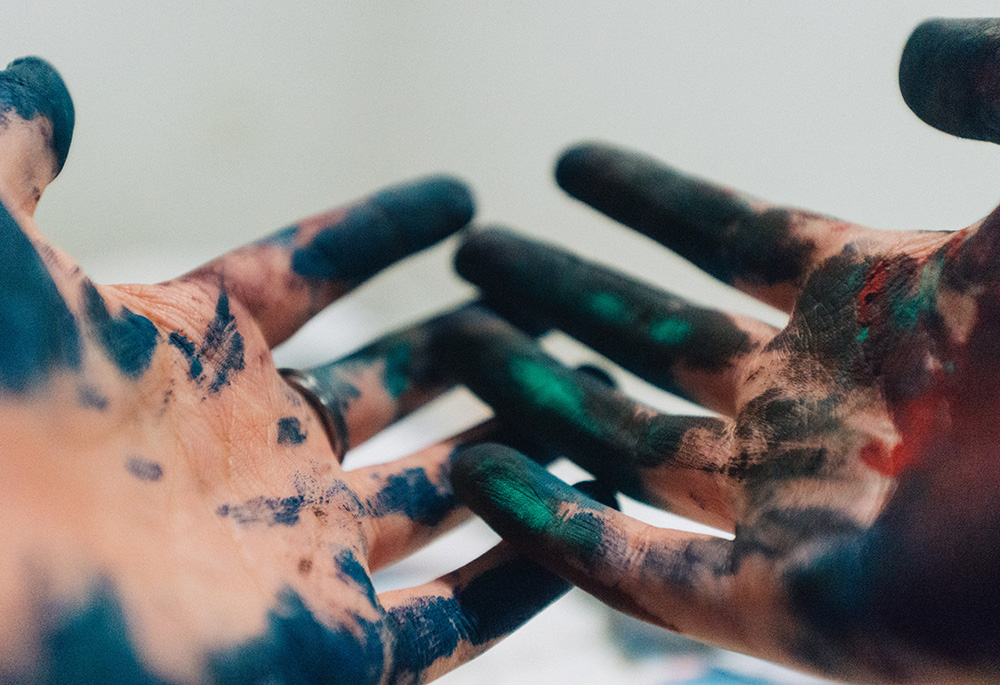 Hands covered in paint (Unsplash/Amauri Mejía)