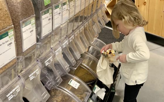 Kara Daddario Bown's 3-year-old daughter fills a reusable cotton bag with food from the bulk section of a grocery store. At home, Bown and her daughter transfer the bulk food into glass jars that they store in their pantry. (Courtesy of Kara Daddario Bown)