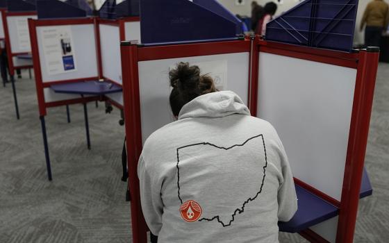 A person with an outline of the state of Ohio on the back of their hoodie, fills out a ballot during early in-person voting at the Hamilton County Board of Elections Nov. 2, 2023, in Cincinnati. (AP photo/Carolyn Kaster)
