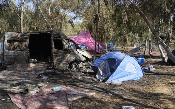 Tents, debris and a burned out van are scattered about the site of a music festival near the border with the Gaza Strip in southern Israel on Oct. 12. At least 260 Israeli festival-goers were killed during the attack by Hamas gunmen on Oct. 7. (AP/Ohad Zwigenberg)