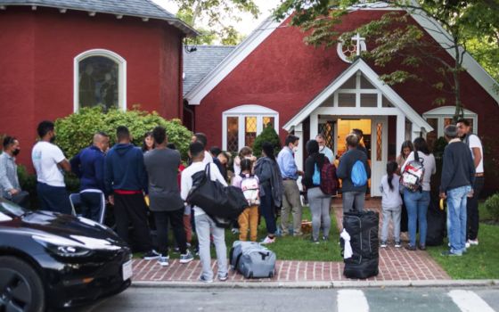 Immigrants gather with their belongings outside St. Andrew's Episcopal Church, Sept. 14, in Edgartown, Massachusetts, on Martha's Vineyard. (Vineyard Gazette via AP/Ray Ewing)